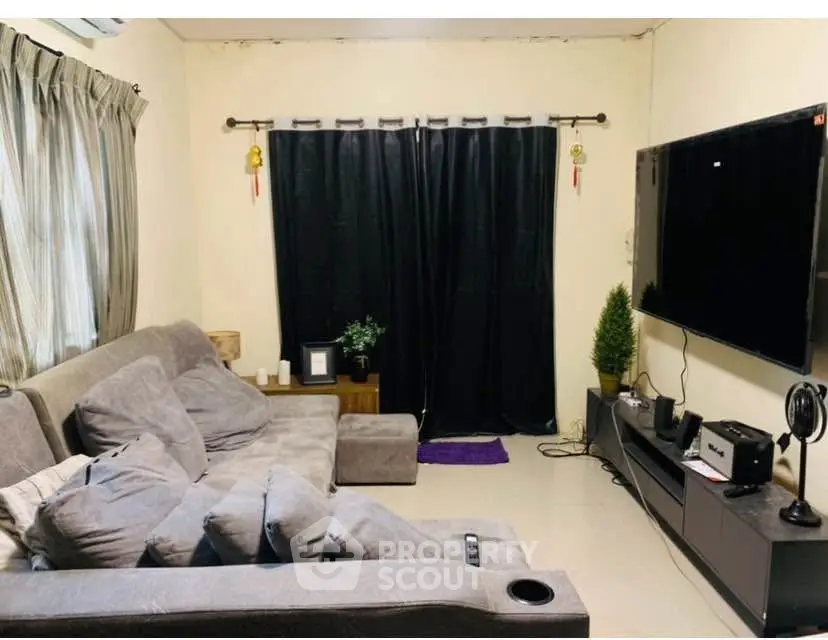 Cozy living room with modern entertainment setup and plush gray sofa.