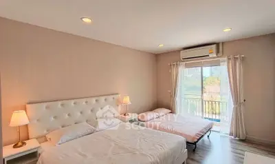 Spacious bedroom with two beds and balcony view in modern apartment