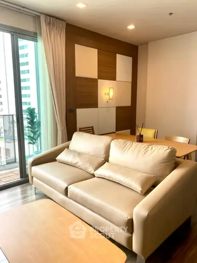 Modern living room with beige sofa and balcony view in stylish apartment