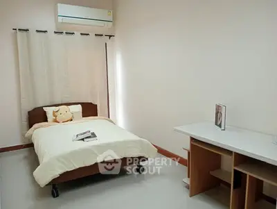 Cozy bedroom with single bed, air conditioning, and study desk, ideal for comfortable living.