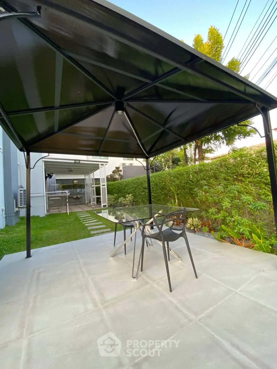 Modern outdoor patio with sleek furniture and lush greenery, perfect for relaxation and entertaining.