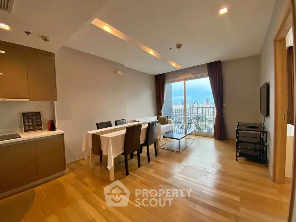 Spacious living room with dining area and stunning city view from balcony.