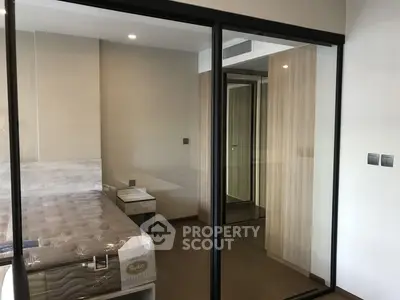 Modern bedroom with glass partition and wooden flooring