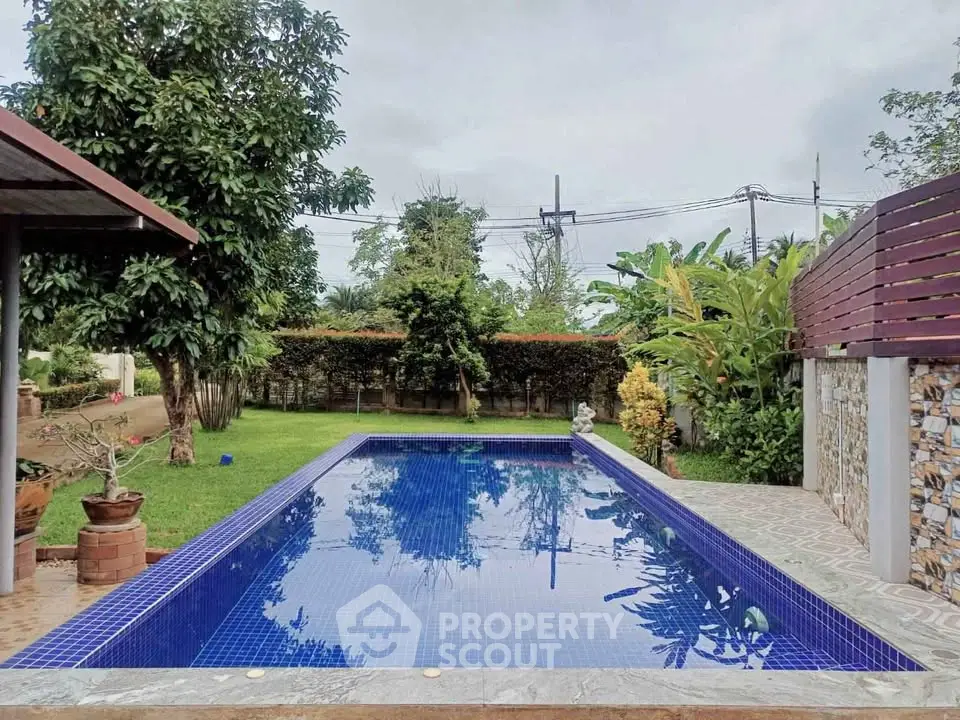 Charming backyard with a serene pool surrounded by lush greenery, perfect for relaxation and outdoor enjoyment.