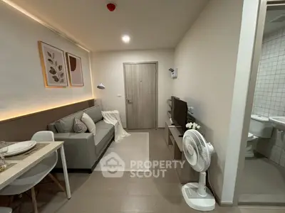 Modern living room with cozy decor and open layout, featuring a comfortable sofa and stylish dining area.