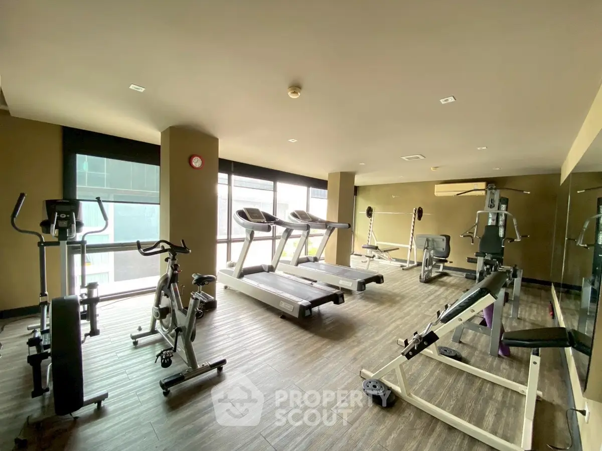 Modern gym with state-of-the-art fitness equipment and large windows for natural light.