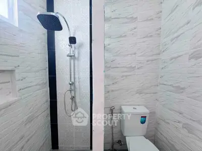 Modern bathroom with sleek shower and white tiled walls, perfect for a contemporary home.