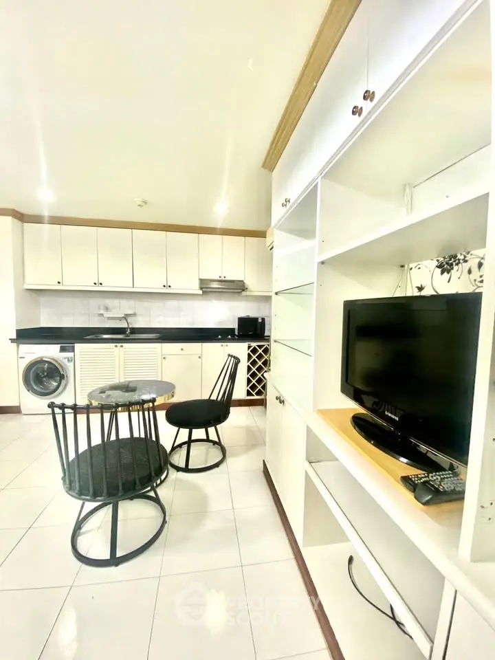 Modern kitchen with open layout, dining area, and built-in appliances in a bright apartment.