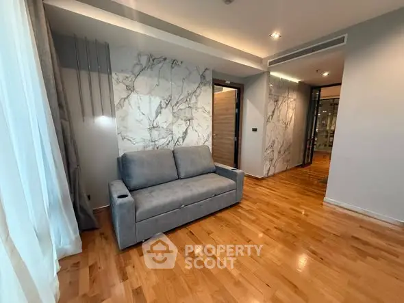 Modern living room with elegant marble accents and cozy gray sofa