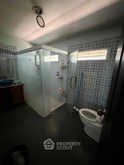 Spacious bathroom with glass shower enclosure and modern fixtures.
