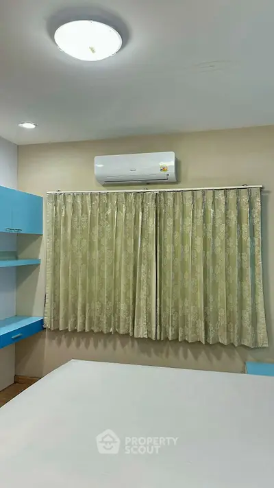 Cozy bedroom with air conditioning and elegant curtains, perfect for a comfortable living experience.