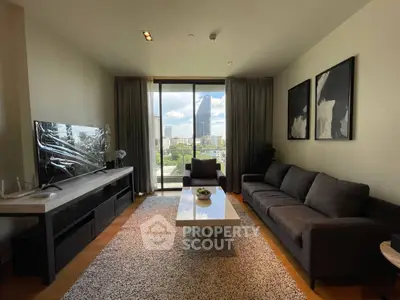 Spacious living room with modern decor and city view, featuring a cozy sofa and elegant artwork.
