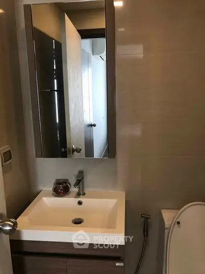 Modern bathroom with sleek sink and mirror in contemporary apartment.