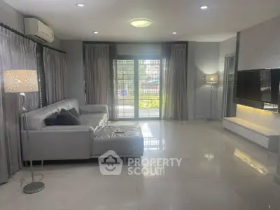 Spacious modern living room with sleek gray sofa and large windows for natural light.
