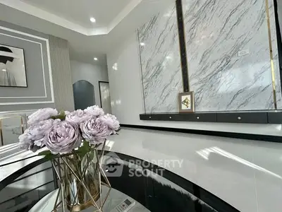 Luxurious modern living room with elegant marble wall and chic decor.