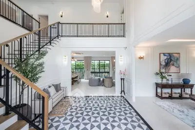 Luxurious open-plan living room with elegant staircase and modern decor