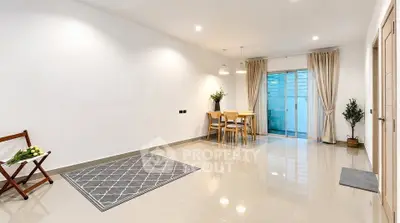 Spacious modern living room with elegant dining area and large windows.