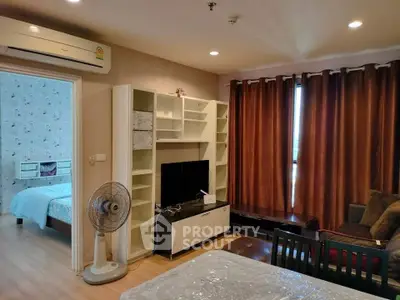 Cozy living room with modern furniture and adjacent bedroom view
