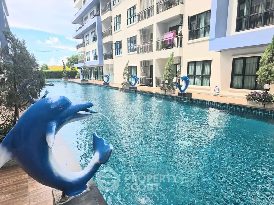 Luxurious apartment complex with stunning pool and dolphin fountain feature.