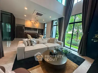 Luxurious modern living room with high ceilings and garden view, featuring elegant decor and open layout.