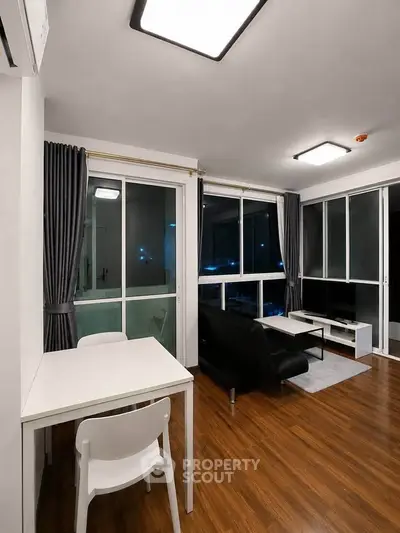 Modern living room with sleek furniture and large windows in a stylish apartment.