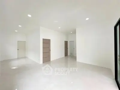 Spacious modern interior with sleek white walls and recessed lighting, perfect for customization.