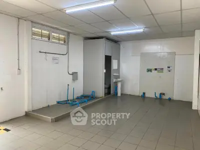 Spacious utility area with plumbing setup and tiled flooring