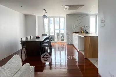 Spacious open-plan living and dining area with modern kitchen and wooden flooring.