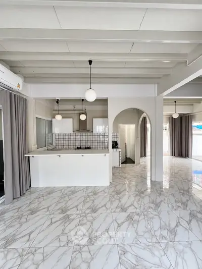 Spacious open-plan kitchen with marble flooring and modern lighting