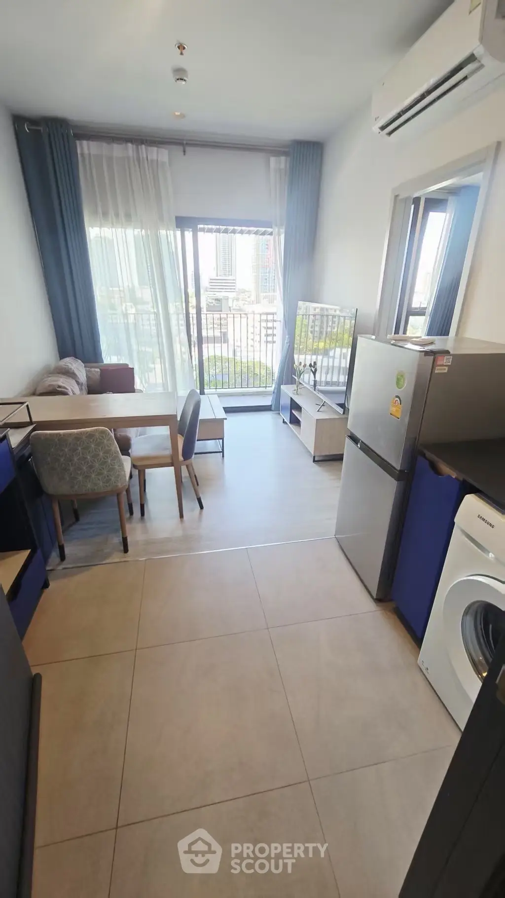 Modern apartment living room with balcony view, featuring sleek furniture and appliances.
