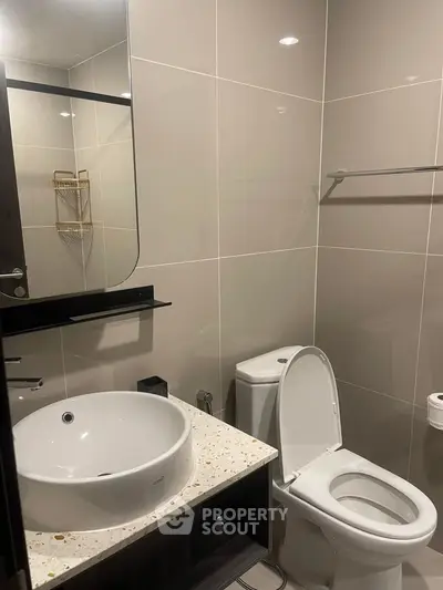 Modern bathroom with sleek fixtures and elegant design, featuring a stylish sink and toilet.