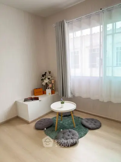 Cozy minimalist living room with natural light and floor seating