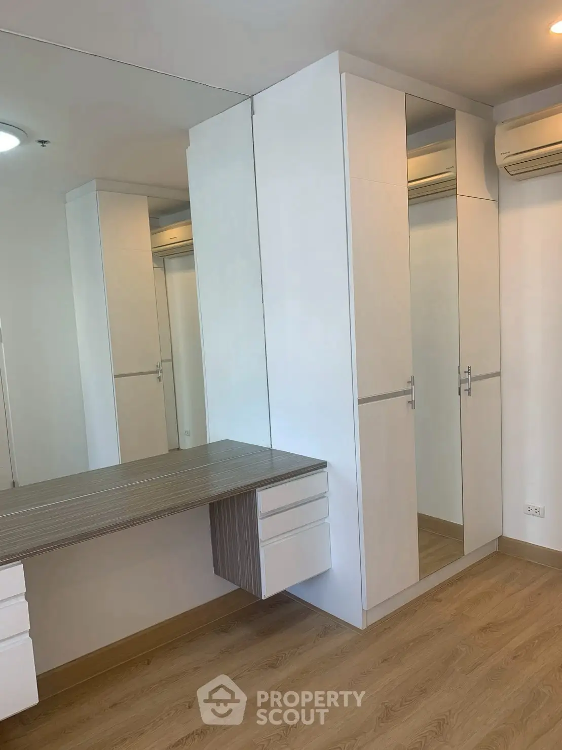 Modern bedroom with built-in wardrobe and sleek wooden flooring