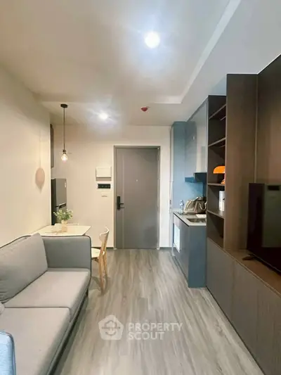 Modern compact living room with open kitchen, sleek design and cozy ambiance.