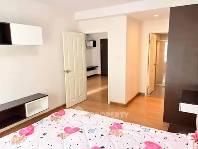 Spacious bedroom with wooden flooring and modern decor in a cozy apartment.