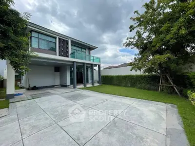 Modern two-story house with spacious driveway and lush green garden