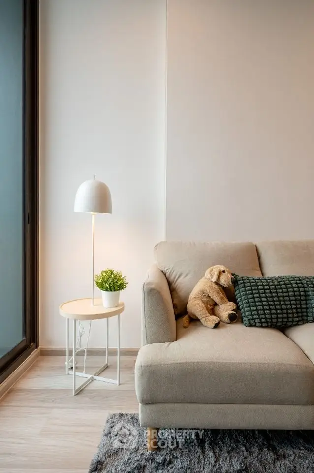 Cozy living room with modern sofa, plush toy, and stylish lamp for a warm ambiance.