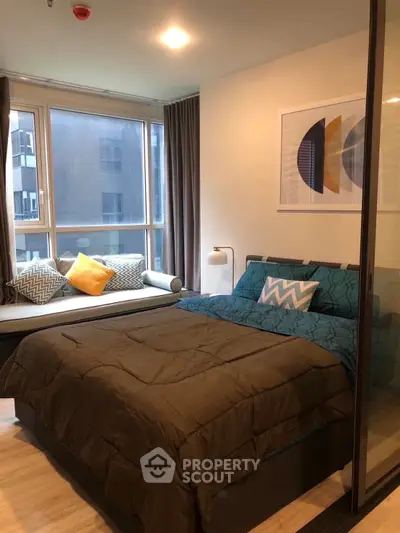 Modern bedroom with large windows offering ample natural light, stylish decor, and a cozy ambiance perfect for relaxation in a prime location.