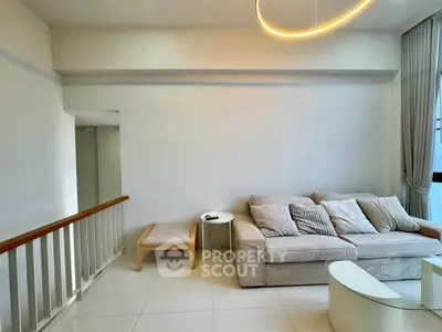 Spacious living room with modern sofa and elegant lighting in a bright apartment.