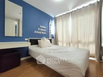 Cozy bedroom with blue accent wall and ample natural light