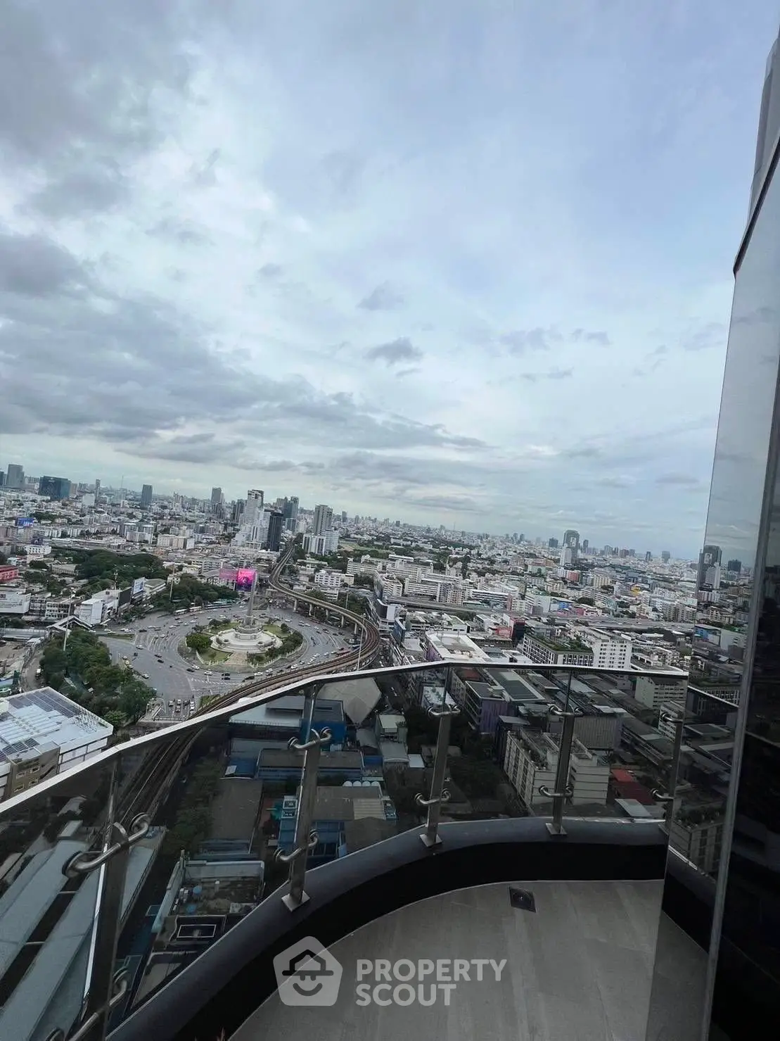 Stunning cityscape view from a high-rise balcony with modern railing.