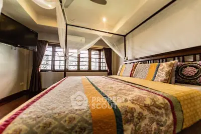 Cozy bedroom with large windows and elegant decor in a charming home.