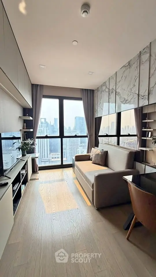 Modern living room with city view, featuring sleek furniture and large windows for natural light.