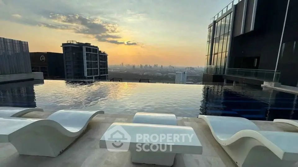 Luxurious rooftop infinity pool with stunning city skyline view at sunset.