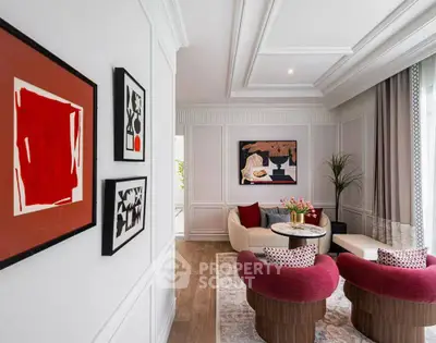 Elegant living room with modern art and stylish furniture, featuring a cozy seating area and natural light.