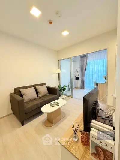 Modern living room with cozy sofa and stylish decor, featuring a bright balcony view.