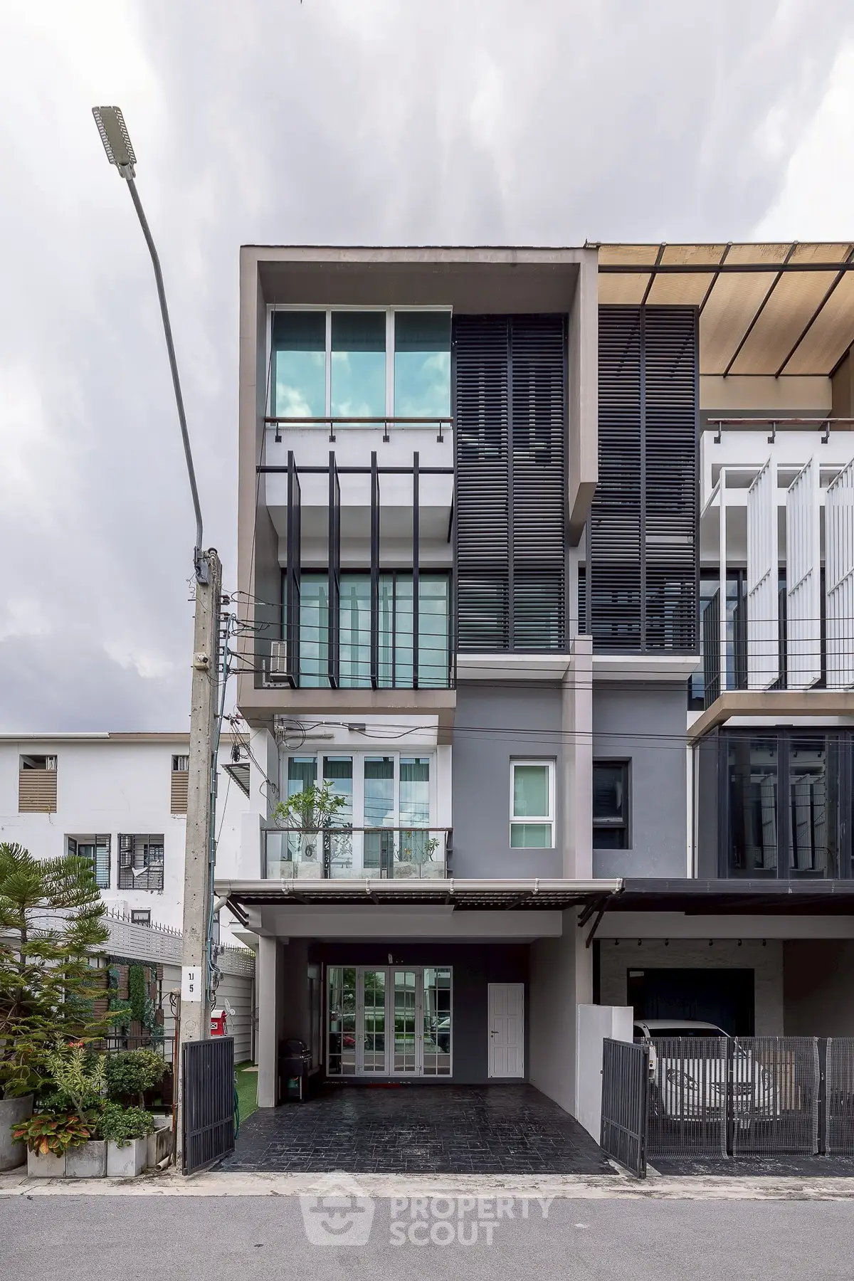 Modern multi-story townhouse with sleek design and spacious balconies in urban setting.