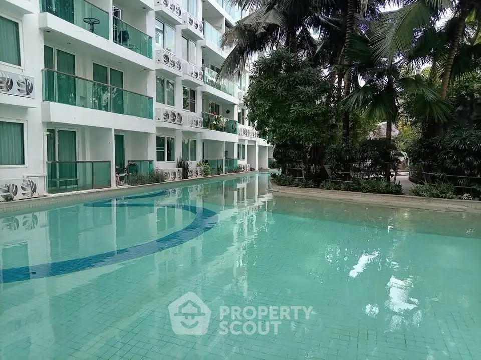 Luxurious apartment complex with serene pool and lush greenery