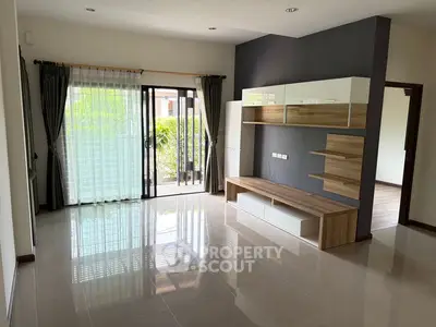 Spacious modern living room with sleek built-in furniture and large sliding glass doors to garden.