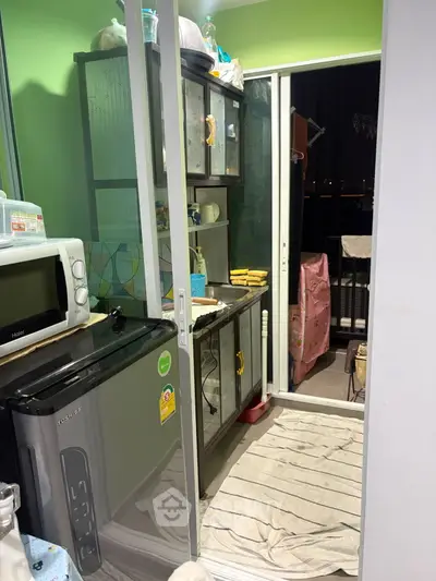 Compact kitchen with modern appliances and balcony access in urban apartment